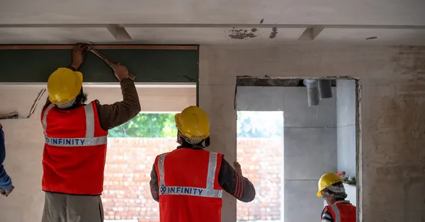 Construction workers renovating interior space in Delhi with safety gear and tools. construction workers in action at delhi site
